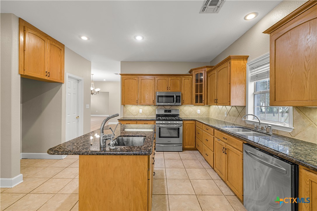 233 Post Oak Bend Inez, TX 77968 - Photo 12 of 45 a large kitchen with granite countertop a large counter top space a sink stainless steel appliances and cabinets