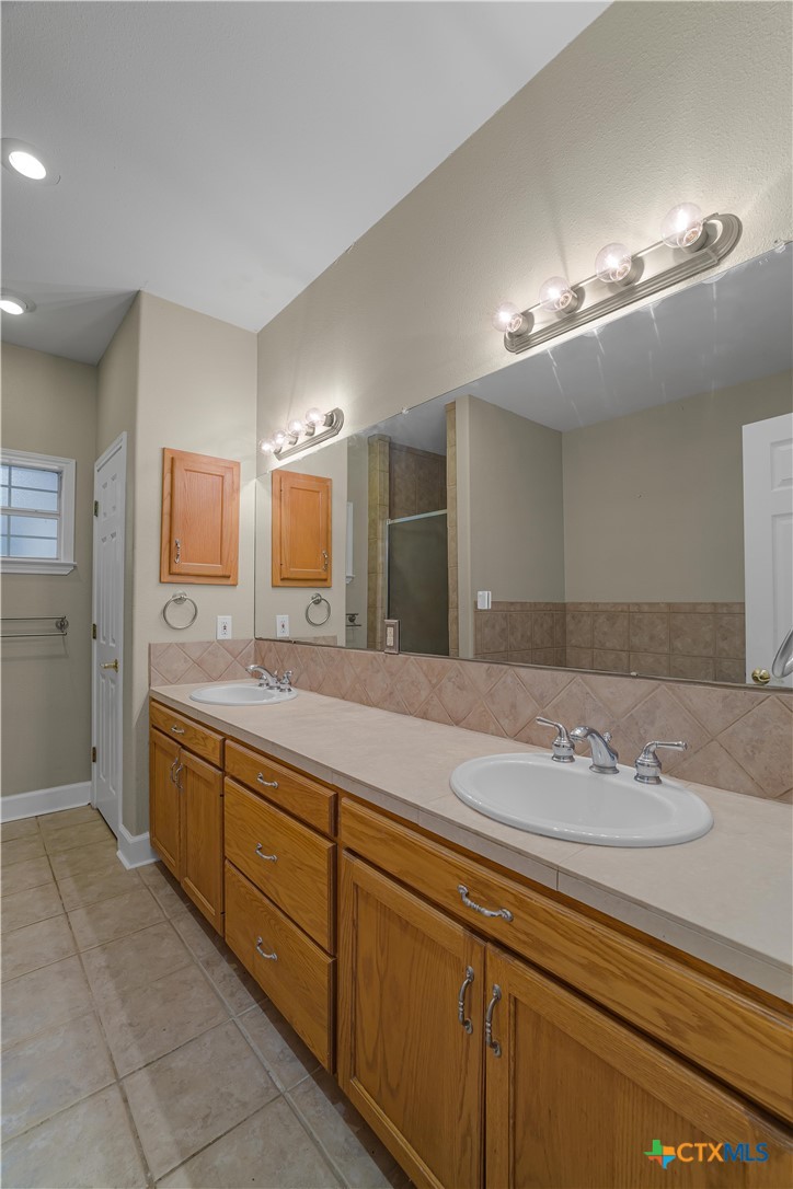 233 Post Oak Bend Inez, TX 77968 - Photo 25 of 45 a bathroom with a granite countertop sink a large mirror and a shower
