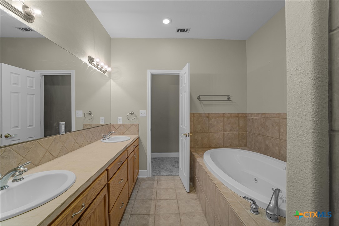 233 Post Oak Bend Inez, TX 77968 - Photo 26 of 45 a spacious bathroom with a tub sink and mirror