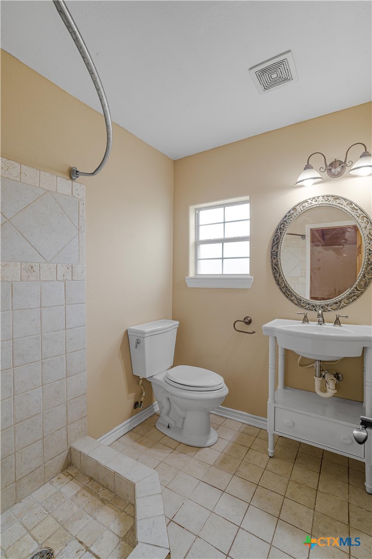 233 Post Oak Bend Inez, TX 77968 - Photo 36 of 45 a bathroom with a toilet mirror vanity and a shower