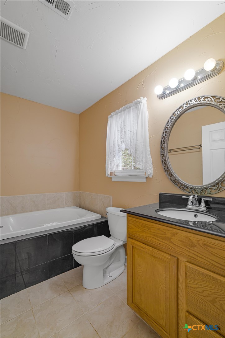 233 Post Oak Bend Inez, TX 77968 - Photo 42 of 45 a bathroom with a toilet a sink and mirror