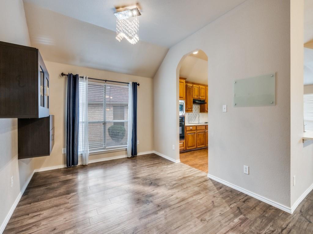 2939 Alyson Way Grand Prairie, TX 75052 - Photo 11 of 20 an empty room with wooden floor cabinet and windows