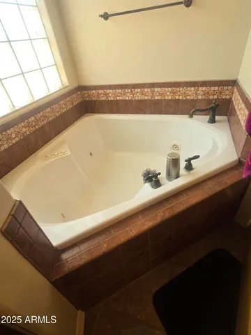 a bathroom with a bathtub and next to a window