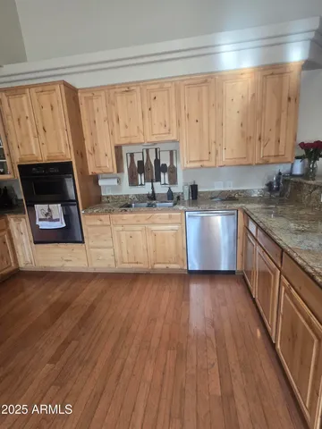 a kitchen with wooden floors and wooden cabinets