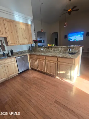 a kitchen with stainless steel appliances granite countertop a sink stove and wooden floor