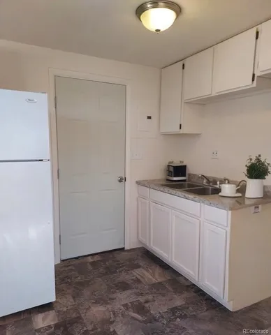 a kitchen with a refrigerator sink and cabinets