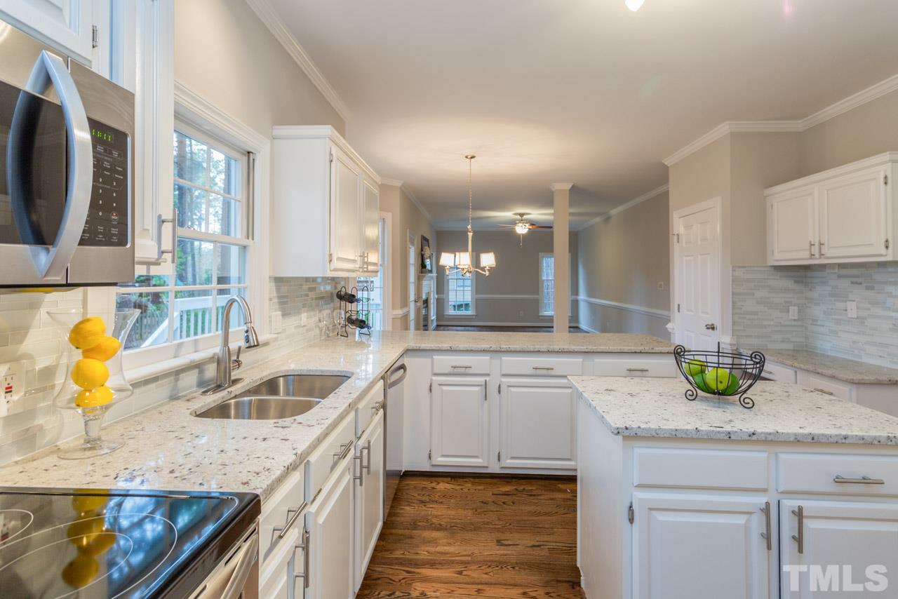5505 Raddington Street Raleigh, NC 27613 - Photo 2 of 25 a kitchen with granite countertop a sink a stove and cabinets
