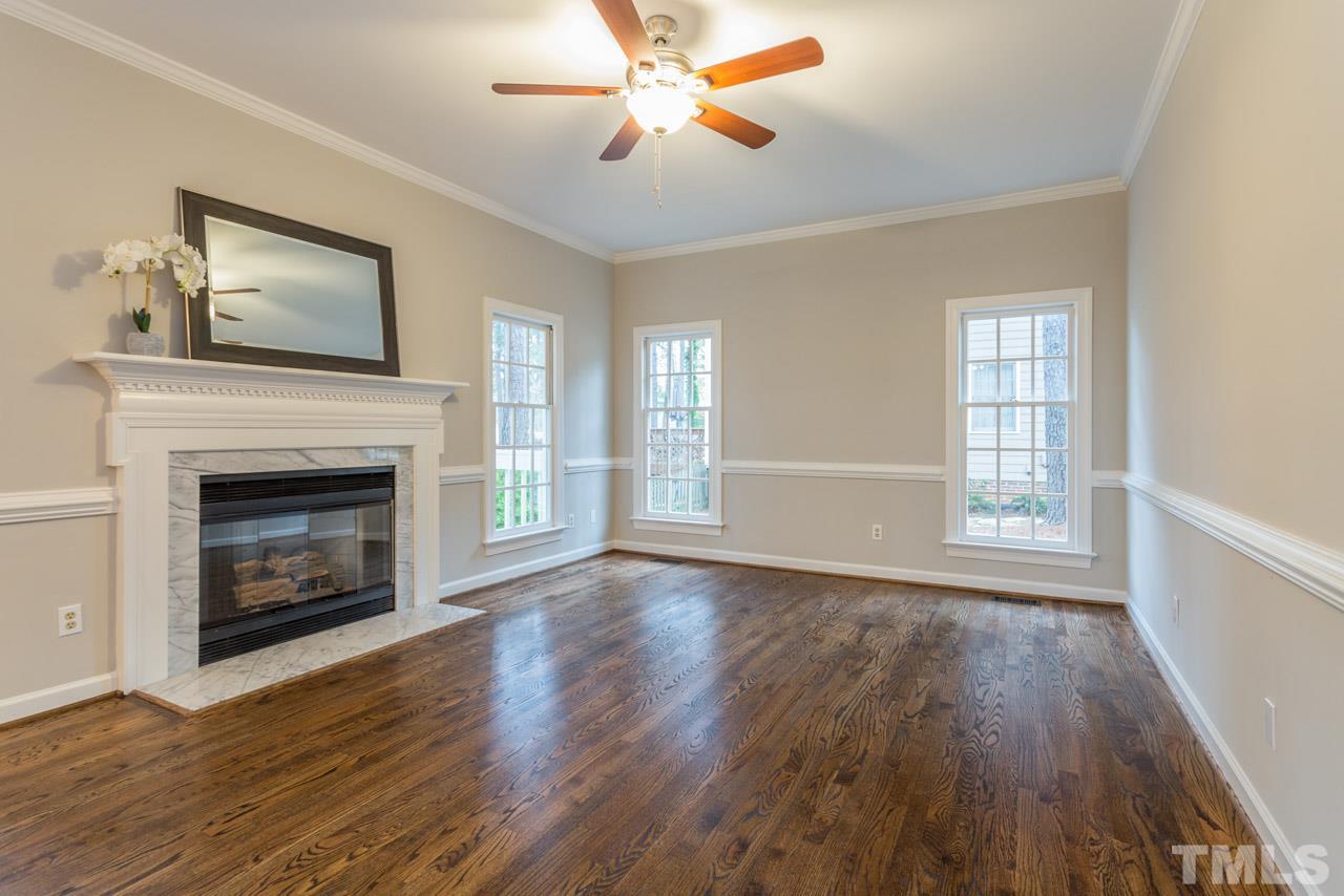 5505 Raddington Street Raleigh, NC 27613 - Photo 5 of 25 a view of an empty room with wooden floor fireplace and a window