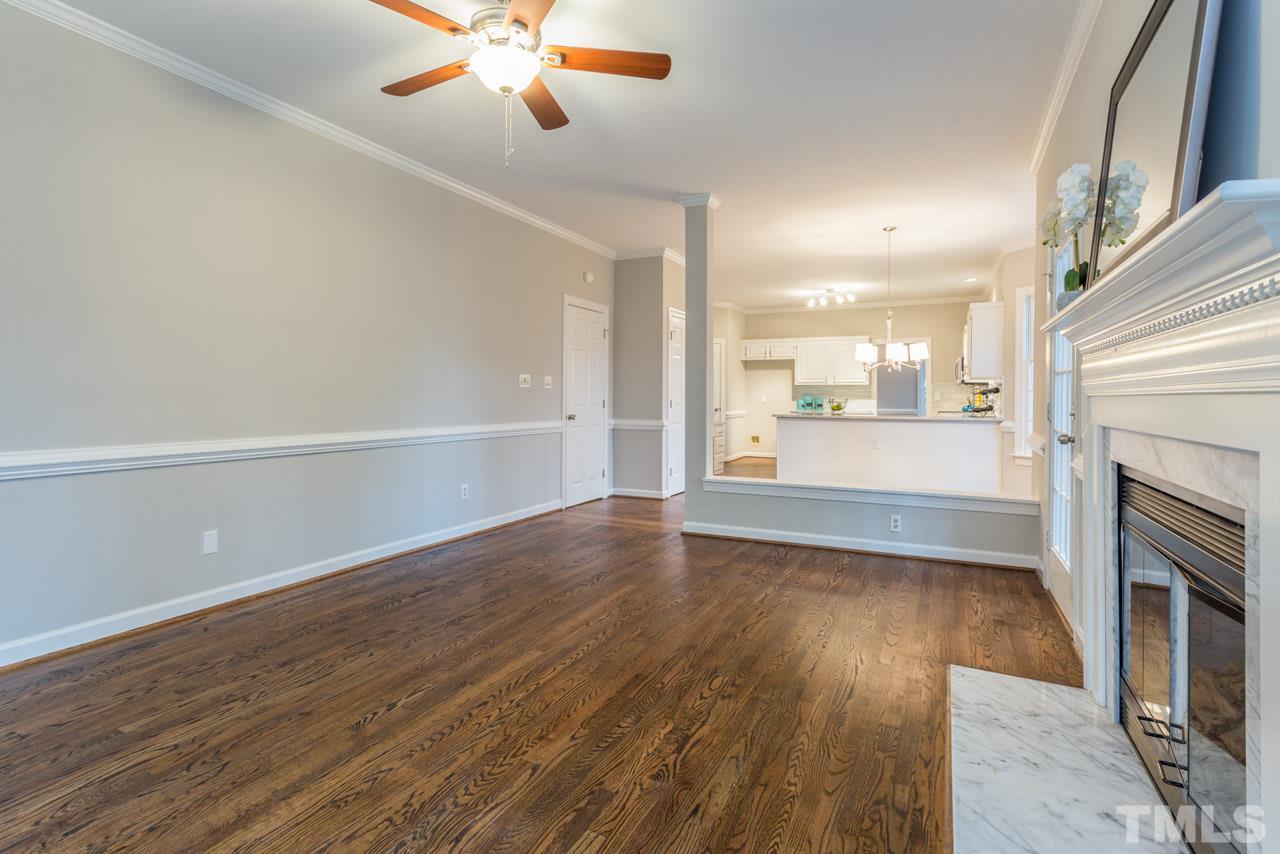 5505 Raddington Street Raleigh, NC 27613 - Photo 6 of 25 an empty room with wooden floor fireplace and windows