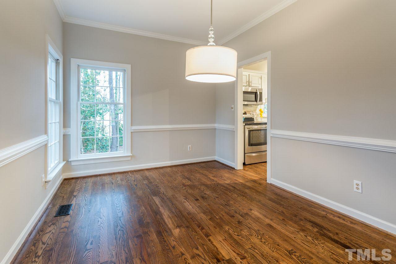 5505 Raddington Street Raleigh, NC 27613 - Photo 8 of 25 a view of an empty room with wooden floor fridge and a window