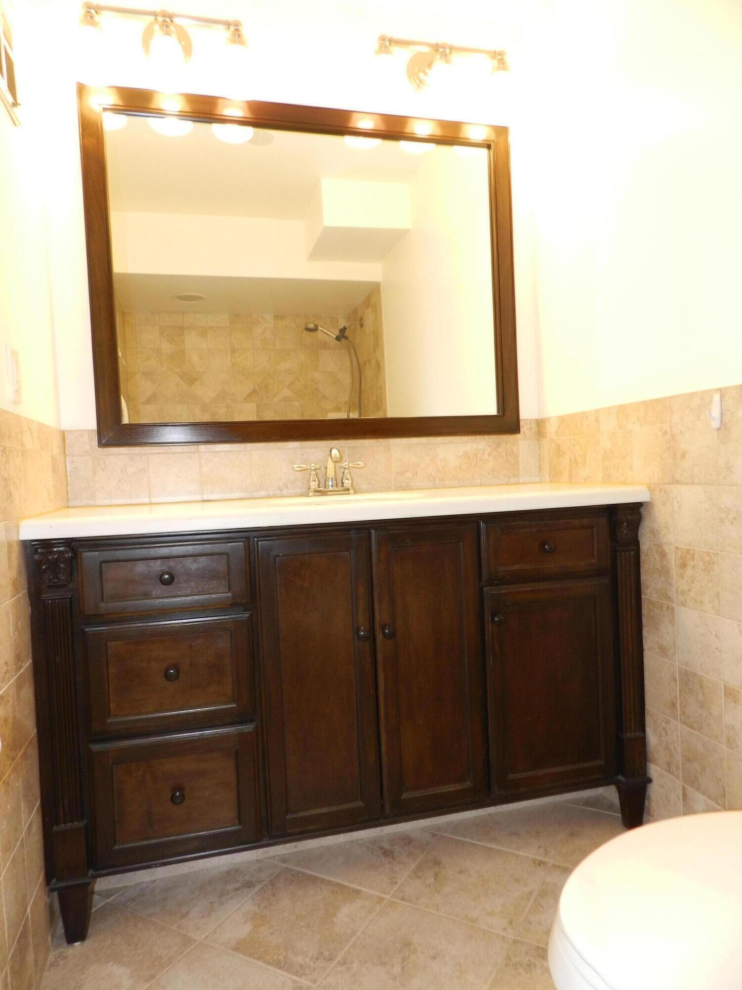 3 Greenway Village North, Unit 108 Royal Palm Beach, FL 33411 - Photo 15 of 29 a bathroom with a sink a mirror and a toilet