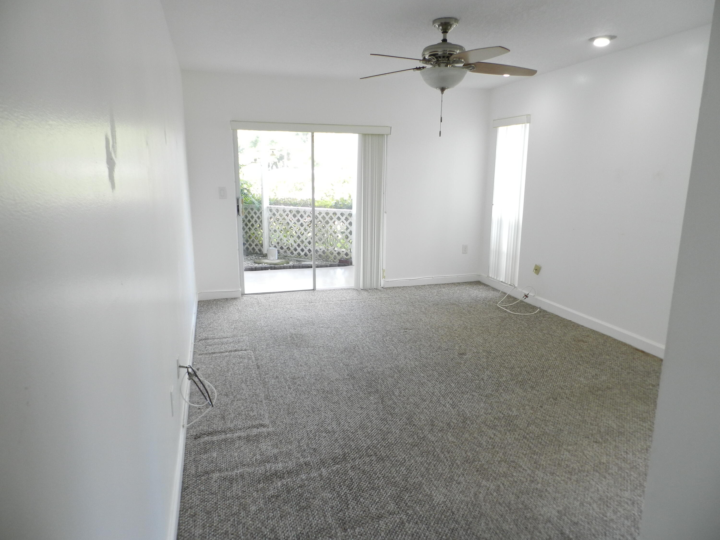 3 Greenway Village North, Unit 108 Royal Palm Beach, FL 33411 - Photo 17 of 29 an empty room with windows and fan