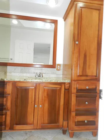 a bathroom with a granite countertop sink and a mirror