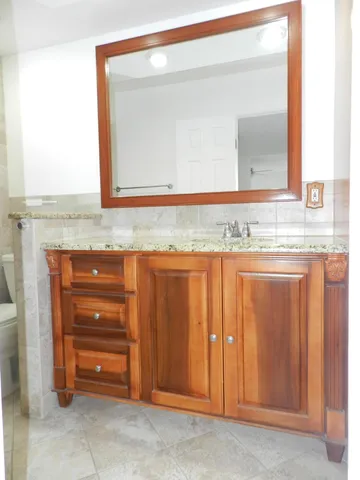 a bathroom with a granite countertop sink and a mirror