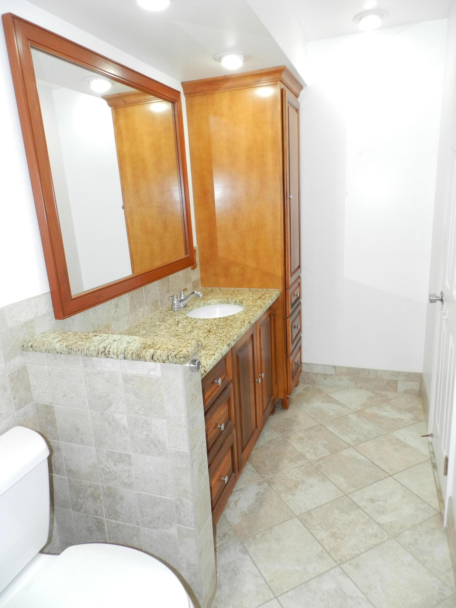 3 Greenway Village North, Unit 108 Royal Palm Beach, FL 33411 - Photo 25 of 29 a bathroom with a granite countertop sink and a mirror