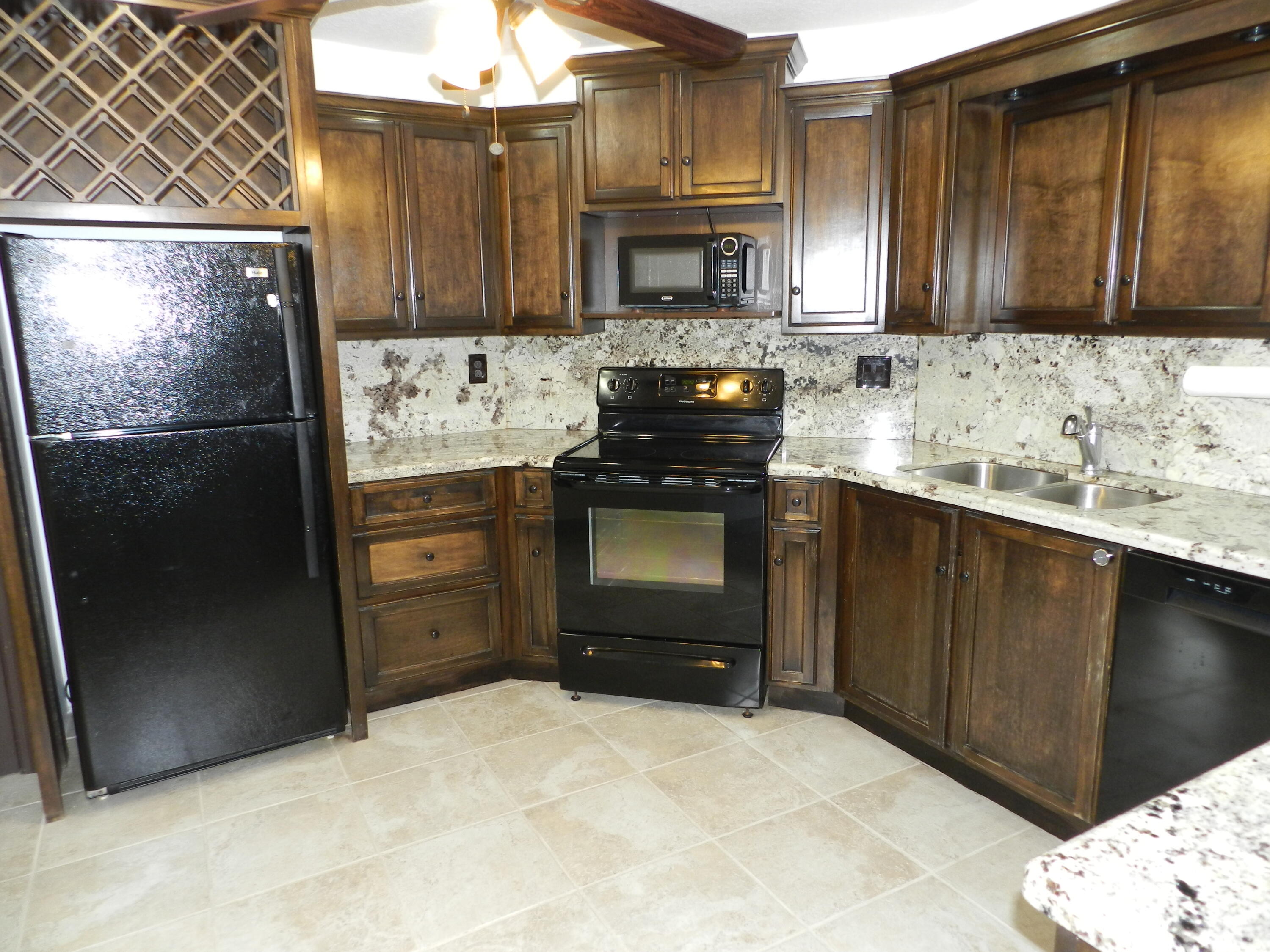 3 Greenway Village North, Unit 108 Royal Palm Beach, FL 33411 - Photo 3 of 29 a kitchen with stainless steel appliances granite countertop a refrigerator and a stove