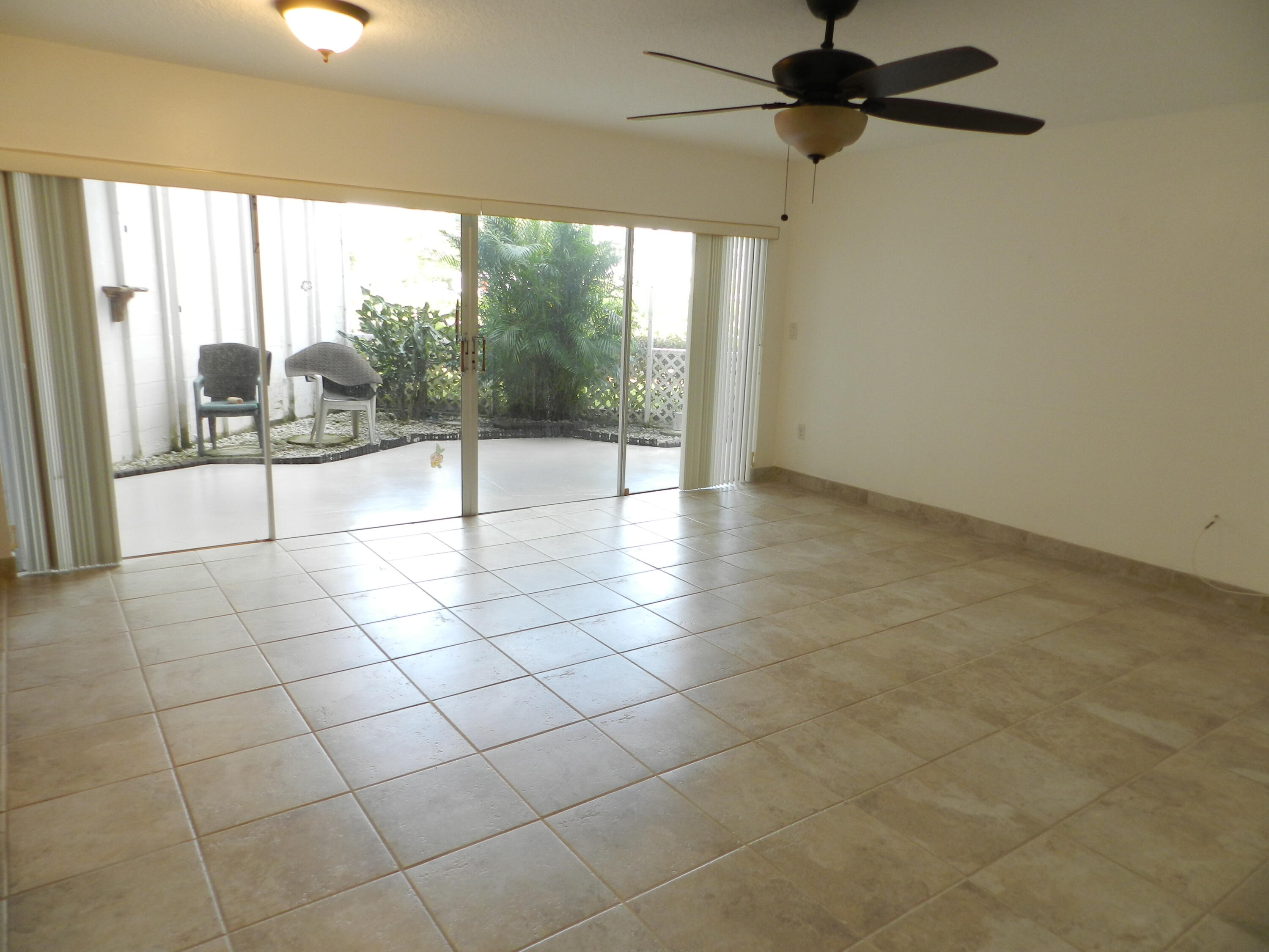 3 Greenway Village North, Unit 108 Royal Palm Beach, FL 33411 - Photo 9 of 29 a view of a livingroom with a floor to ceiling window and an entrance