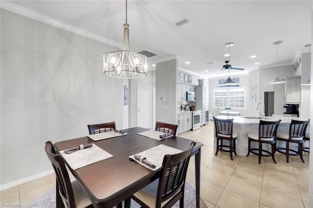 12694 Fox Ridge Drive Bonita Springs, FL 34135 - Photo 14 of 35 a view of a dining room with furniture and chandelier