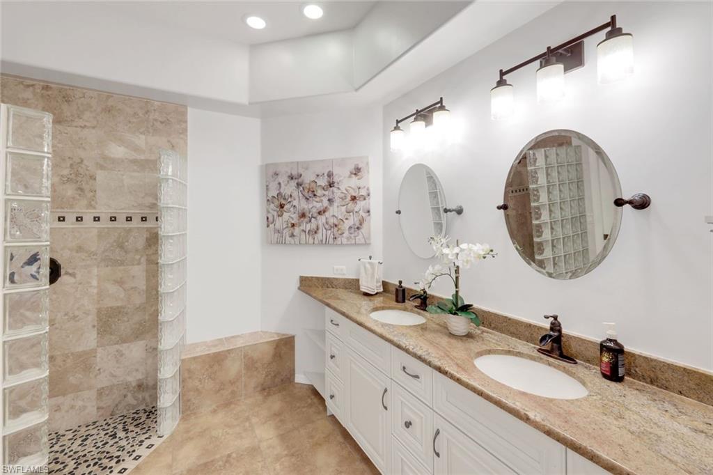 12694 Fox Ridge Drive Bonita Springs, FL 34135 - Photo 20 of 35 a bathroom with a granite countertop sink a mirror and shower
