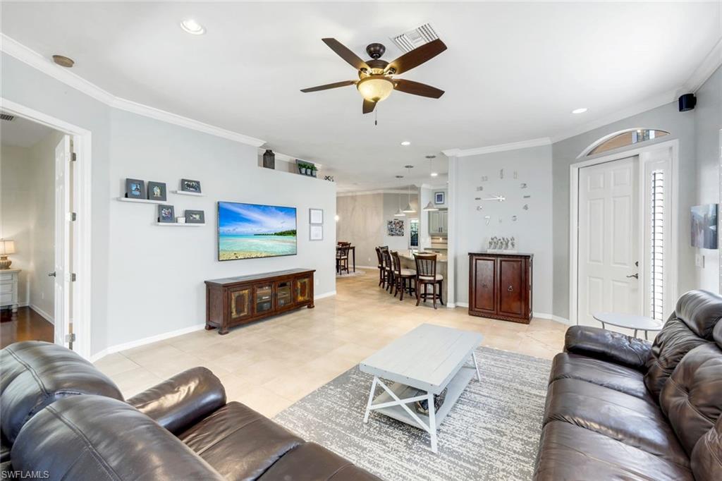 12694 Fox Ridge Drive Bonita Springs, FL 34135 - Photo 7 of 35 a living room with furniture and a flat screen tv with rug
