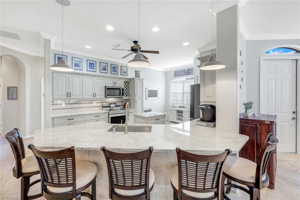 12694 Fox Ridge Drive Bonita Springs, FL 34135 - Photo 9 of 35 a dining room with stainless steel appliances kitchen island granite countertop a dining table chairs and view kitchen
