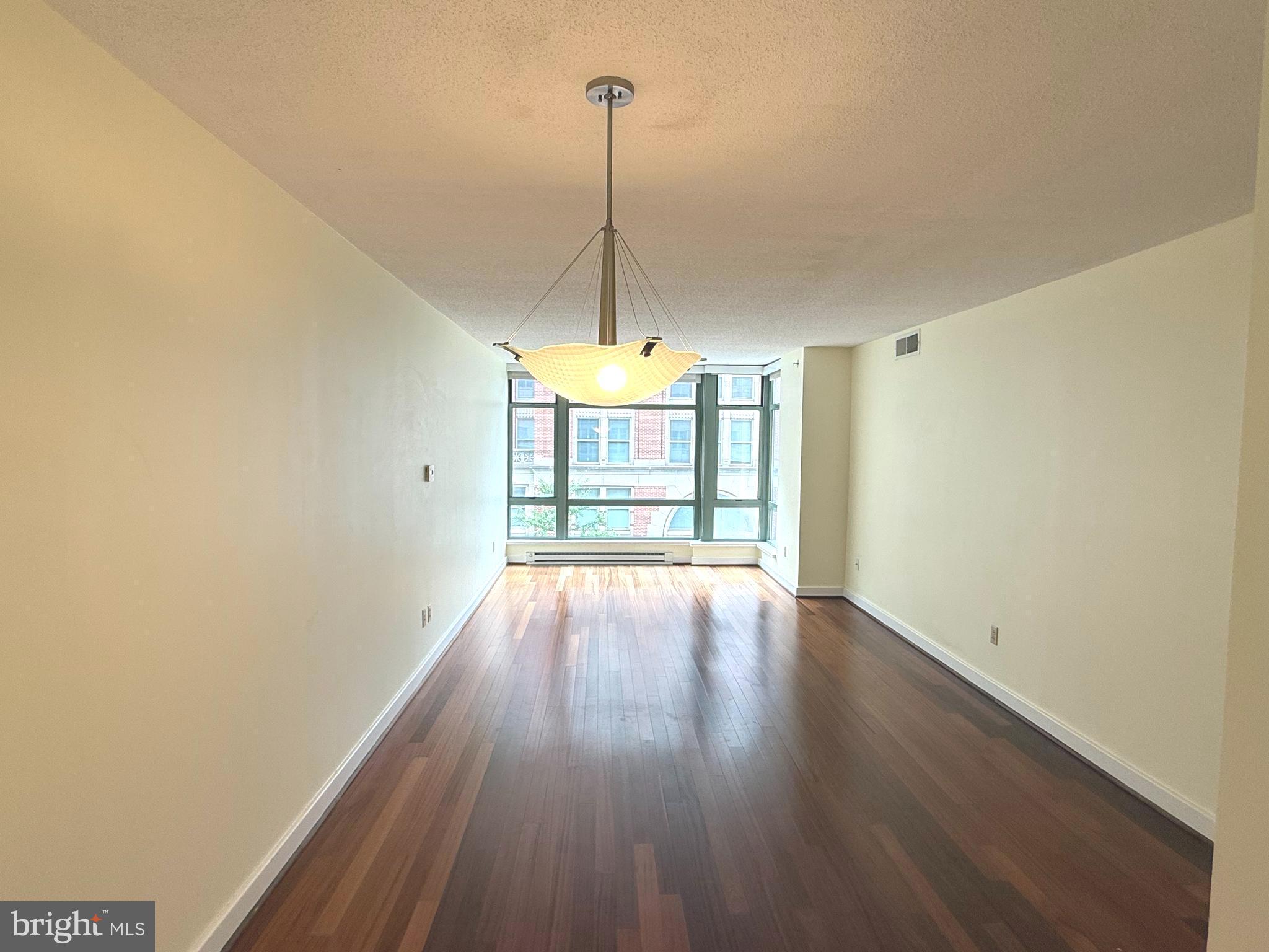 1150 K Street Northwest, Unit 506 Washington, DC 20005 - Photo 5 of 14 a view of empty room with wooden floor and fan