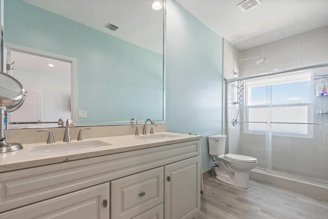 a bathroom with a double vanity sink mirror and toilet