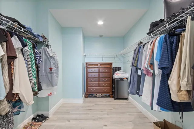 a view of walk in closet with clothes and shoes