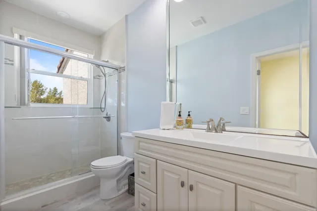 a bathroom with a granite countertop sink mirror vanity and toilet