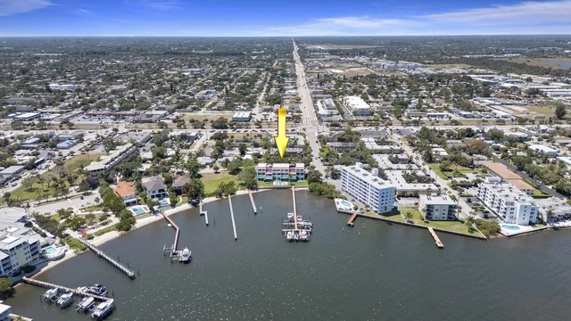 an aerial view of a city with lots of residential buildings ocean and mountain view in back