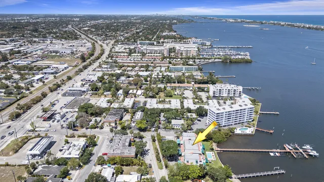an aerial view of ocean and residential houses with outdoor space