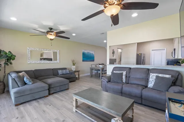 a living room with furniture a ceiling fan and a rug