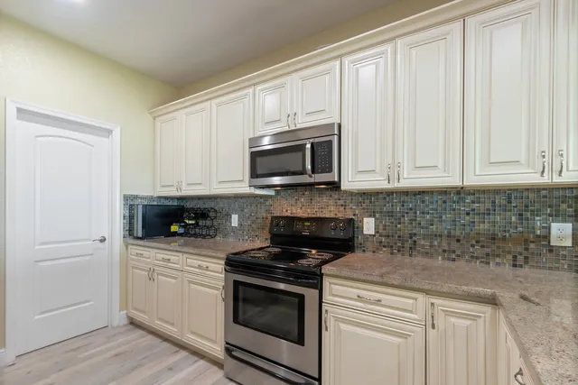 a kitchen with white cabinets and stainless steel appliances