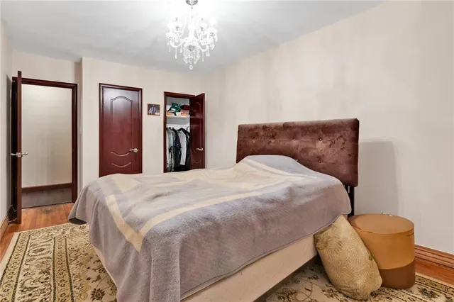 a large bed sitting in a bedroom and a chandelier