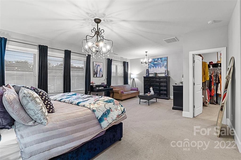 7001 Fallondale Road Waxhaw, NC 28173 - Photo 17 of 32 a bedroom with bed a window and a chandelier