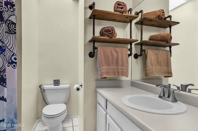 a bathroom with a toilet sink vanity and mirror