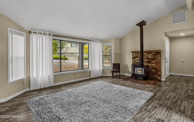 an empty room with floor to ceiling window and fireplace