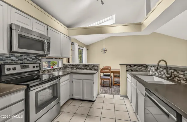 a kitchen with stainless steel appliances a stove sink and cabinets