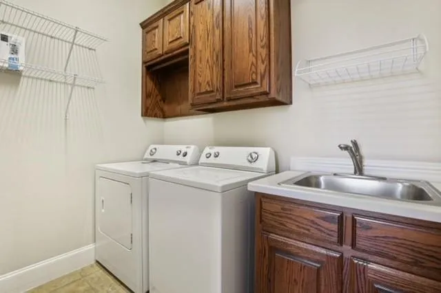 a utility room with sink dryer and washer