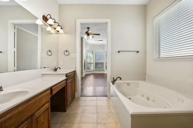 a spacious bathroom with a bathtub sink and mirror