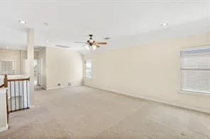 an empty room with a ceiling fan and windows