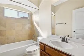 a bathroom with a granite countertop sink a toilet and bathtub