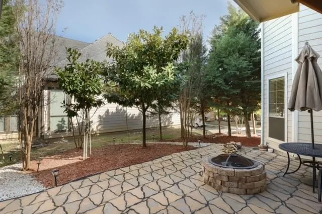 a view of a backyard with table and chairs and potted plants