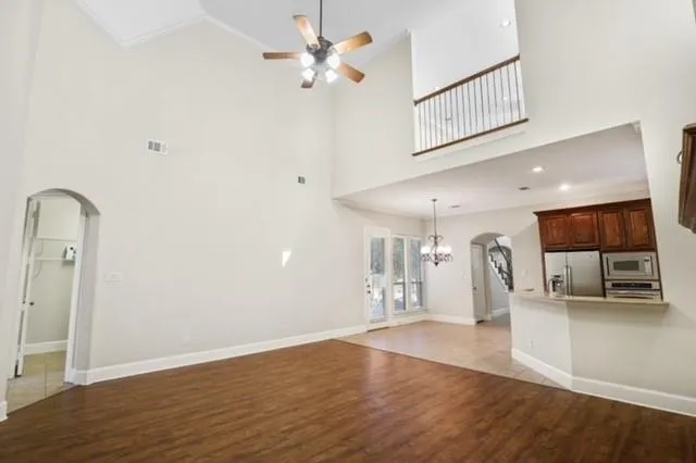 a view of a kitchen with wooden floor and a ceiling fan