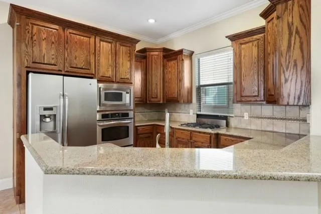 a kitchen with granite countertop a refrigerator and a sink