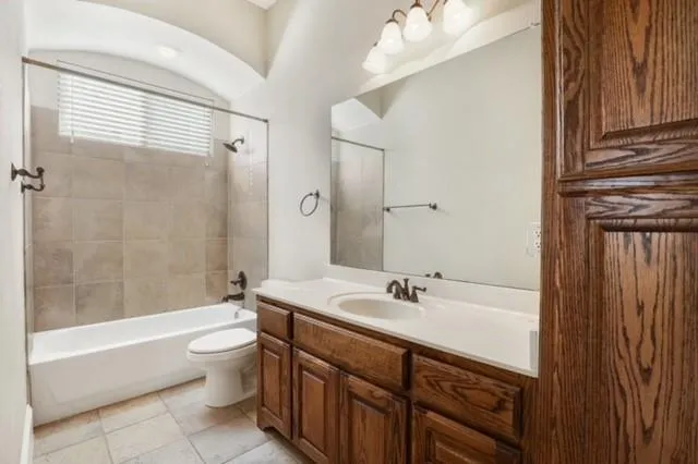 a bathroom with a bathtub shower sink mirror and toilet