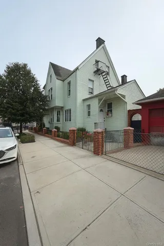 a view of a white house with large windows and a table and chairs