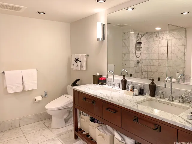 a bathroom with a granite countertop sink a toilet and a mirror