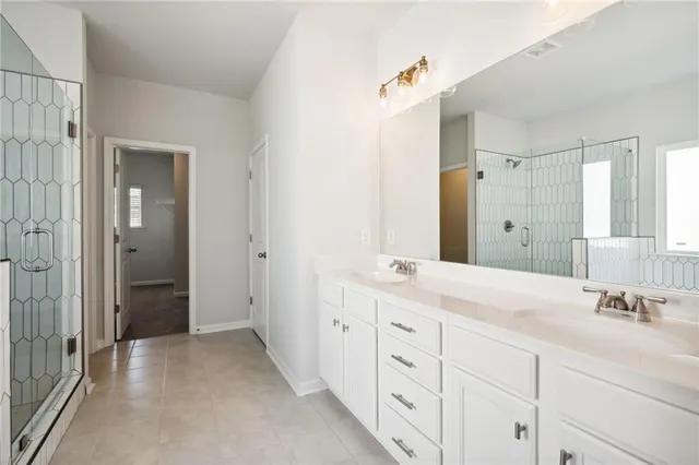 a spacious bathroom with double sink and a mirror