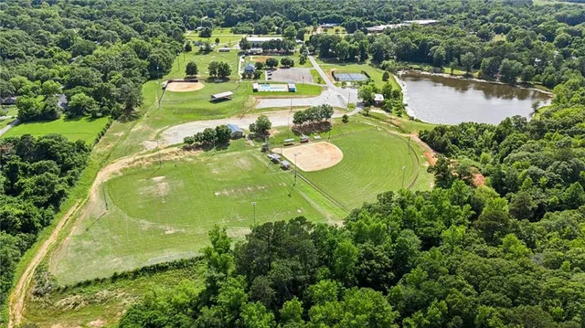 an aerial view of a house with swimming pool and lake view